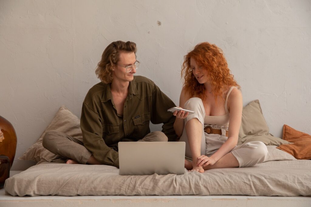 Happy couple browsing laptop at home
